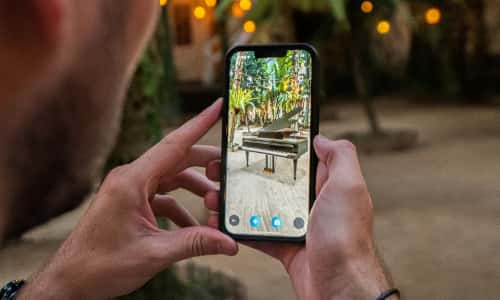 A phone showing an augmented reality piano placed in a garden