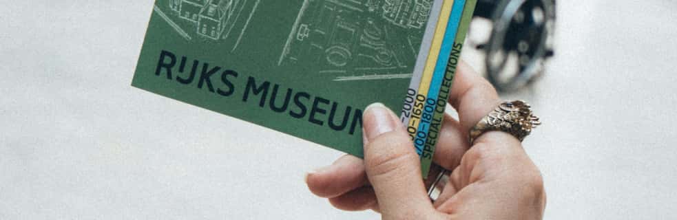 A visitor holding a printed museum guide booklet